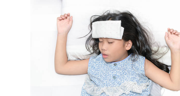 Child lying in bed with a fever compress on forehead during a febrile seizure