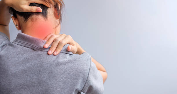 Woman holding neck and shoulder in pain with red highlighted area