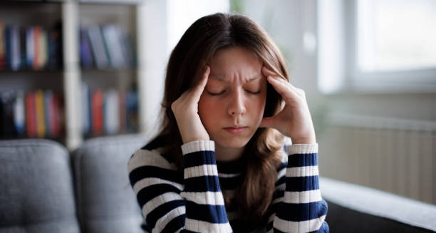 Woman holding her head in pain showing symptoms of Chiari malformation