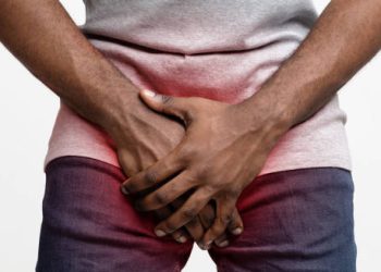 Man holding groin area indicating pain from chlamydia symptoms