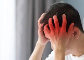 Man clutching head in pain with red highlighted area indicating cluster headache