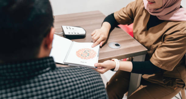 Optometrist using Ishihara test book to check for colour blindness in a patient