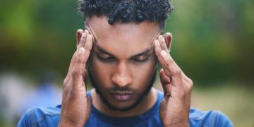Man experiencing headache and disorientation, symptoms of concussion