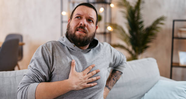 Man clutching his chest, showing signs of respiratory distress, a common symptom of cystic fibrosis.