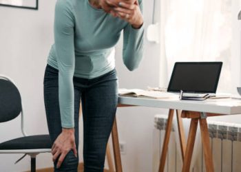 Woman holding her knee in pain, showing symptoms of a dislocated kneecap