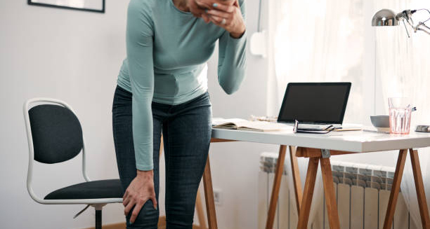 Woman holding her knee in pain, showing symptoms of a dislocated kneecap