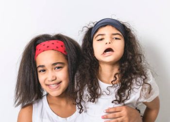 Two young girls, one showing signs of speech difficulty
