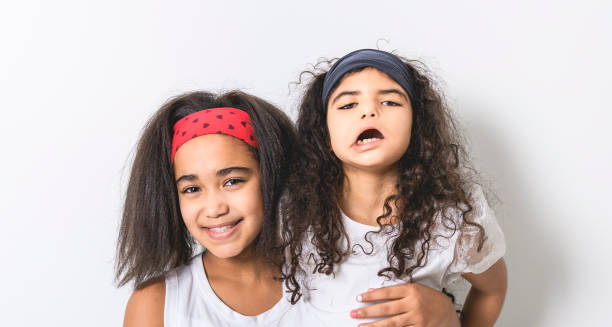 Two young girls, one showing signs of speech difficulty