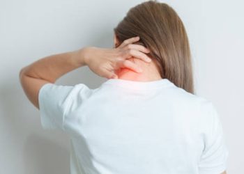 Woman touching the back of her neck in discomfort