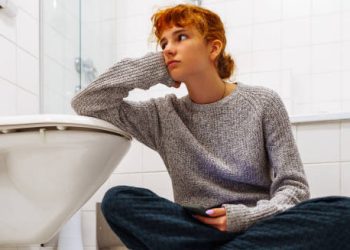 Teenager in bathroom showing distress, a possible sign of eating disorders