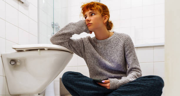 Teenager in bathroom showing distress, a possible sign of eating disorders
