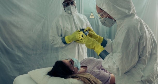 Healthcare workers in protective gear attending to a patient with suspected Ebola symptoms.