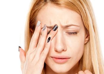 Woman touching her eye in discomfort