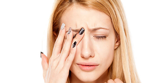 Woman touching her eye in discomfort