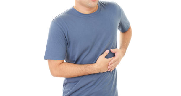 Man holding his side in discomfort, indicating pain that may be a symptom of a cracked rib.