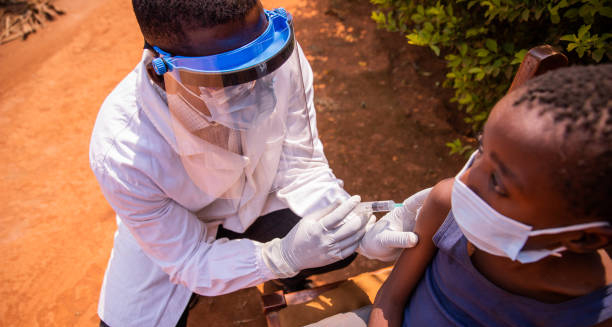 Healthcare worker administering cholera vaccine to a child wearing a face mask
