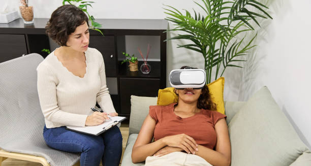 Woman receiving virtual reality therapy for claustrophobia with psychologist present.