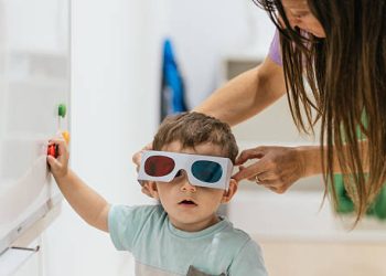 Young child wearing colour correction glasses during vision therapy
