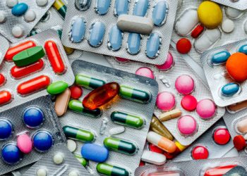 Various blister packs of colourful medication tablets and capsule