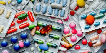Various blister packs of colourful medication tablets and capsule