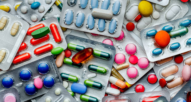 Various blister packs of colourful medication tablets and capsule