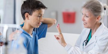Female doctor conducting a concussion assessment on a young boy in hospital