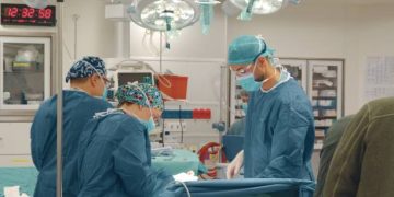 Surgeons performing heart surgery in a sterile operating theatre to treat congenital heart disease