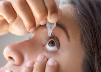 Woman applying eye drops for conjunctivitis treatment