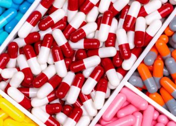 Various colourful capsules and medications arranged in compartments, representing pharmaceutical treatment options.