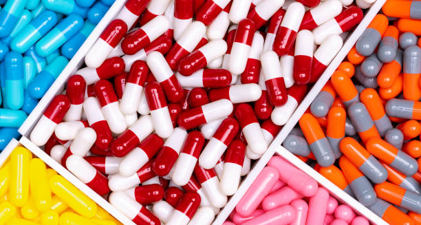 Various colourful capsules and medications arranged in compartments, representing pharmaceutical treatment options.