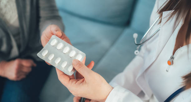 Doctor handing a blister pack of antiviral tablets to a patient