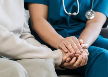 Nurse comforting an elderly patient during dementia care