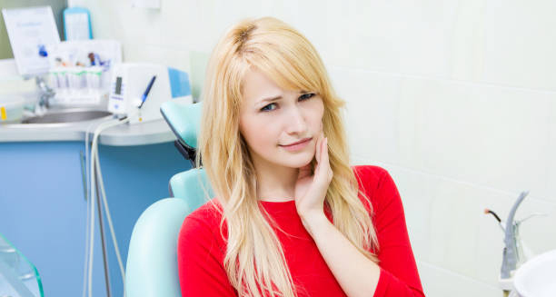 Woman with tooth pain sitting in a dental chair before treatment