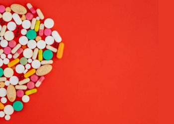 Heart-shaped layout of various antibiotics and pills symbolising treatment for endocarditis.