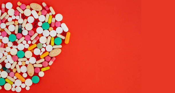 Heart-shaped layout of various antibiotics and pills symbolising treatment for endocarditis.