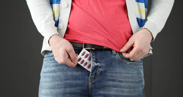 Man placing prostate medication blister pack into trouser pocket