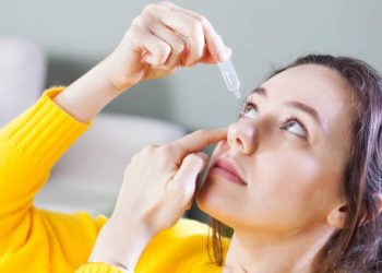 Woman applying eye drops for eye infection