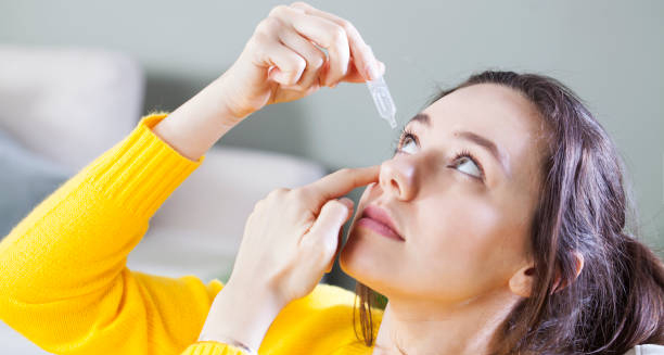 Woman applying eye drops for eye infection