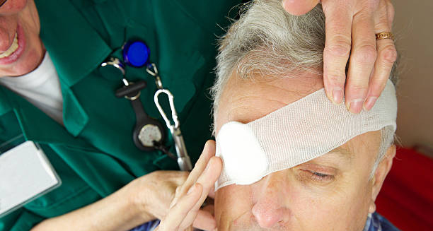 Medical professional applying bandage to injured man's eye