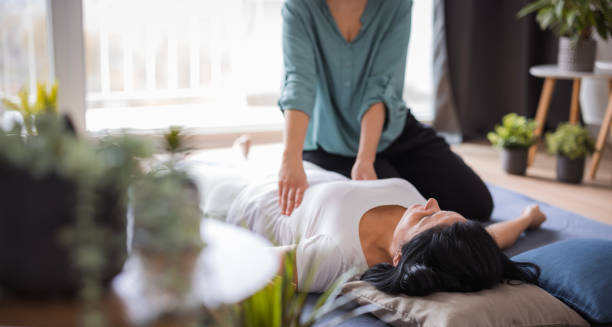 Woman lying on a mat receiving gentle therapeutic care, representing holistic treatment for a cracked rib.