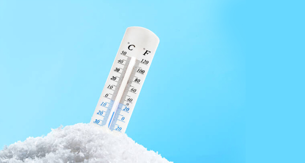 Thermometer stuck in snow showing sub-zero temperature readings