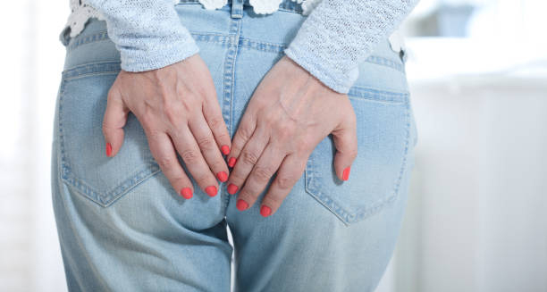 Woman clutching lower back and buttocks in discomfort