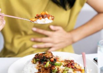 Woman experiencing heartburn after eating spicy food