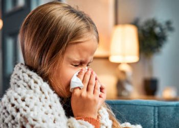 Young girl with flu symptoms and tissue