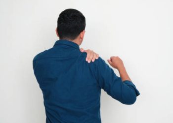 Man clutching his shoulder due to ongoing shoulder pain and stiffness