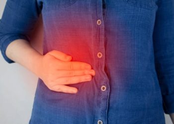 Woman holding her side in pain – Complications of Glandular Fever