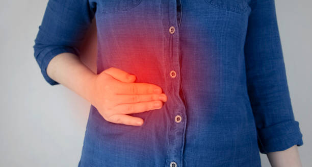 Woman holding her side in pain – Complications of Glandular Fever