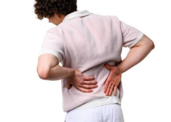 Person holding lower back in pain, indicating kidney-related complications of glomerulonephritis