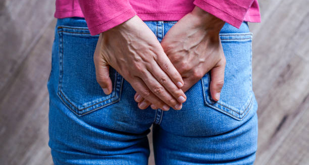 Woman holding bottom due to haemorrhoid discomfort