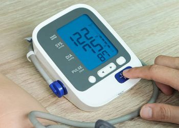 Digital blood pressure monitor showing readings during a cardiac health check